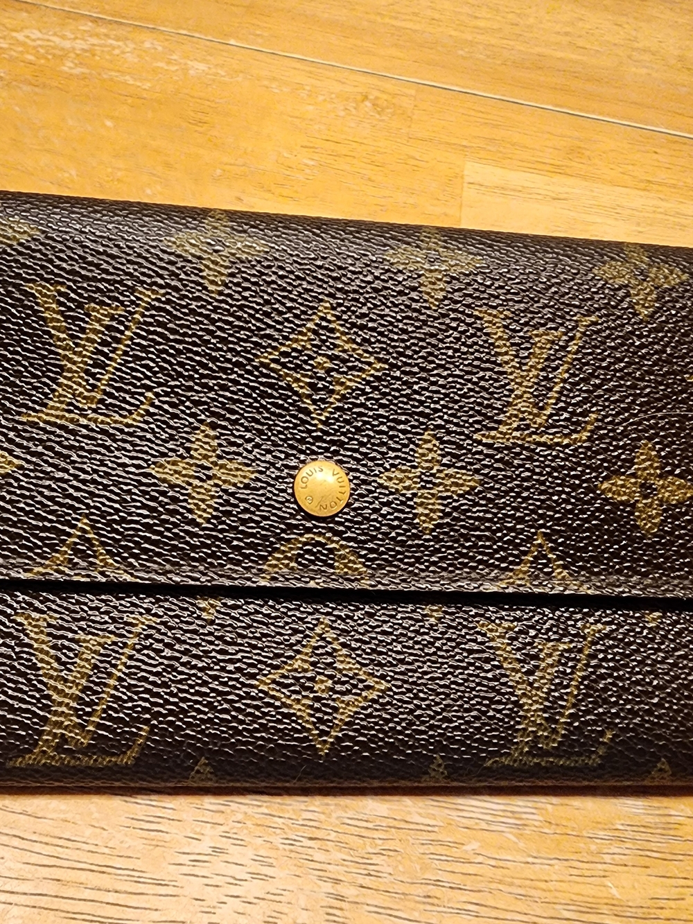 Louis Vuitton Sarah wallet features the iconic monogram canvas exterior